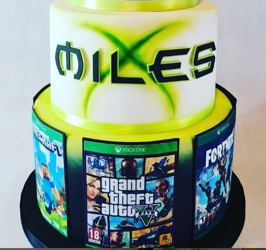 xbox one themed 3 tier cake, printed image of game covers surround the bottom of the cake.