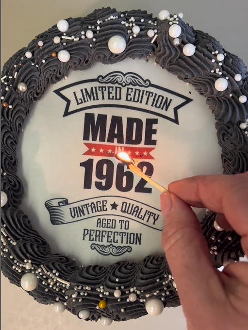 Vintage style cake topper in wafer paper about to be lit to reveal a surprise image underneath