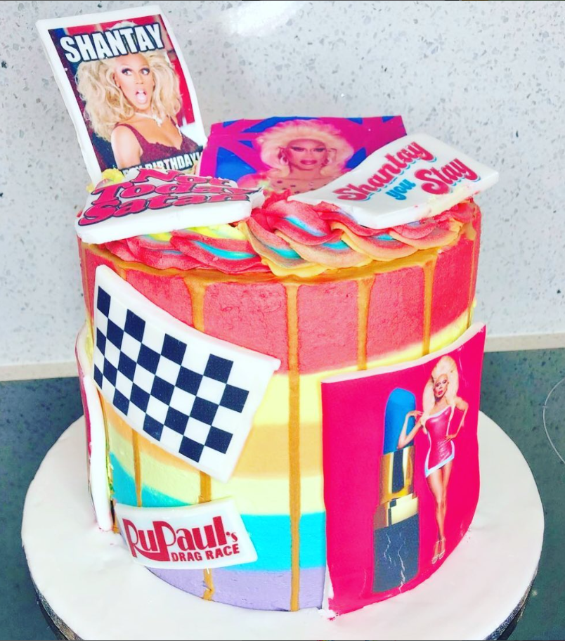 Ru Paul's drag race themed cake, layered in multi coloured icing and covered in edible printed images of the stars and logo