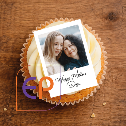 plain iced Cupcake with an edible polaroid photo of two women and 'Happy Mother's Day' text on a wooden background
